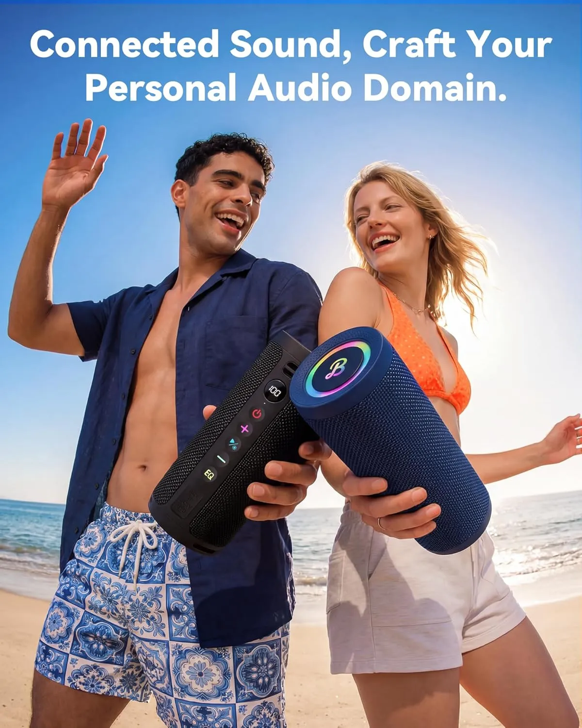 Couple on a beach holding two BassBloom Roar 3 speakers paired for wireless stereo sound