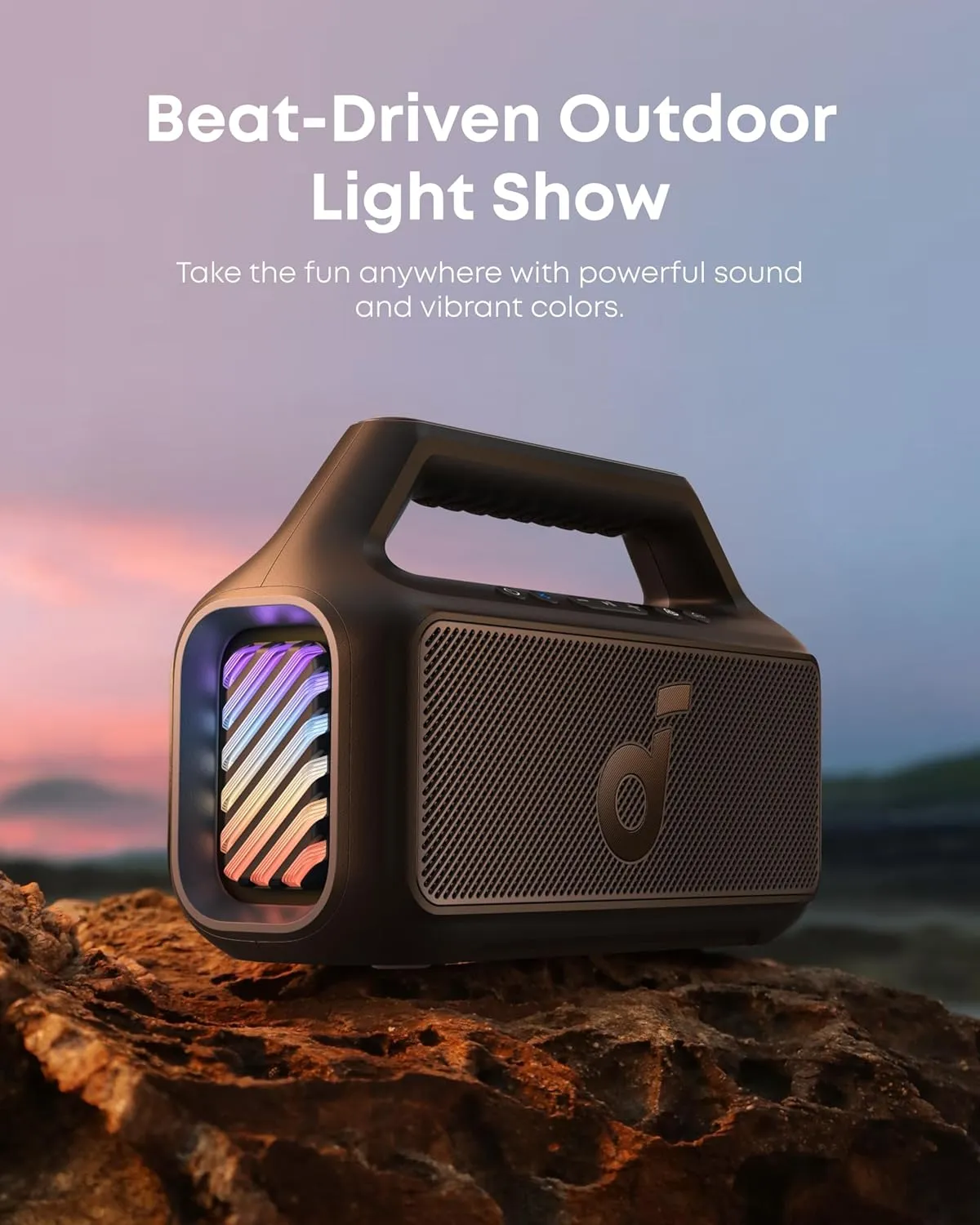 Soundcore Boom 2 on a rock at sunset with its RGB light show active