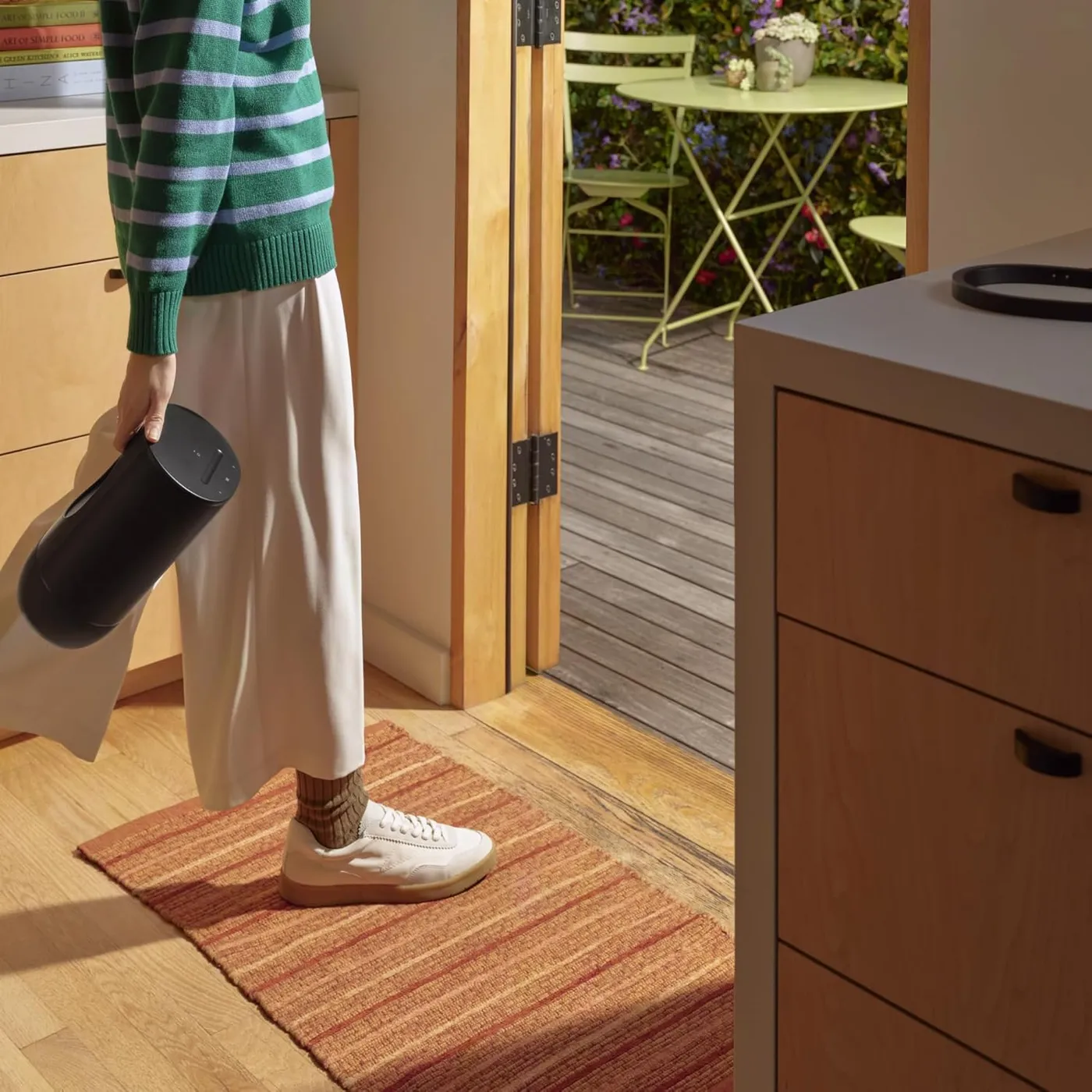 Person carrying the Sonos Move 2 Bluetooth speaker by its built-in handle