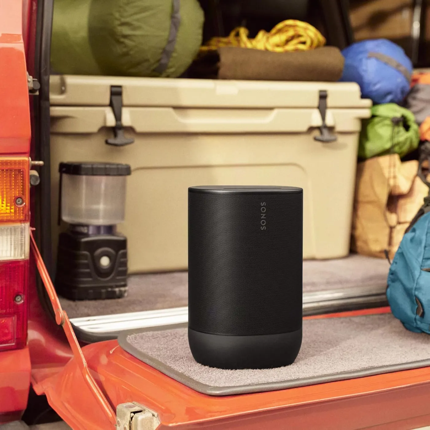 Sonos Move 2 Bluetooth speaker outdoors on a tailgate beside camping gear