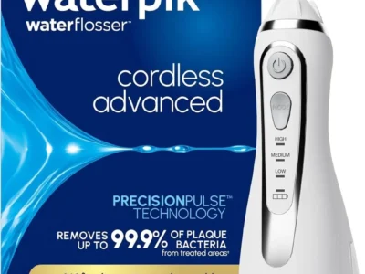 Waterpik Cordless Advanced water flosser handle in white with pressure mode buttons, in front of its blue retail box
