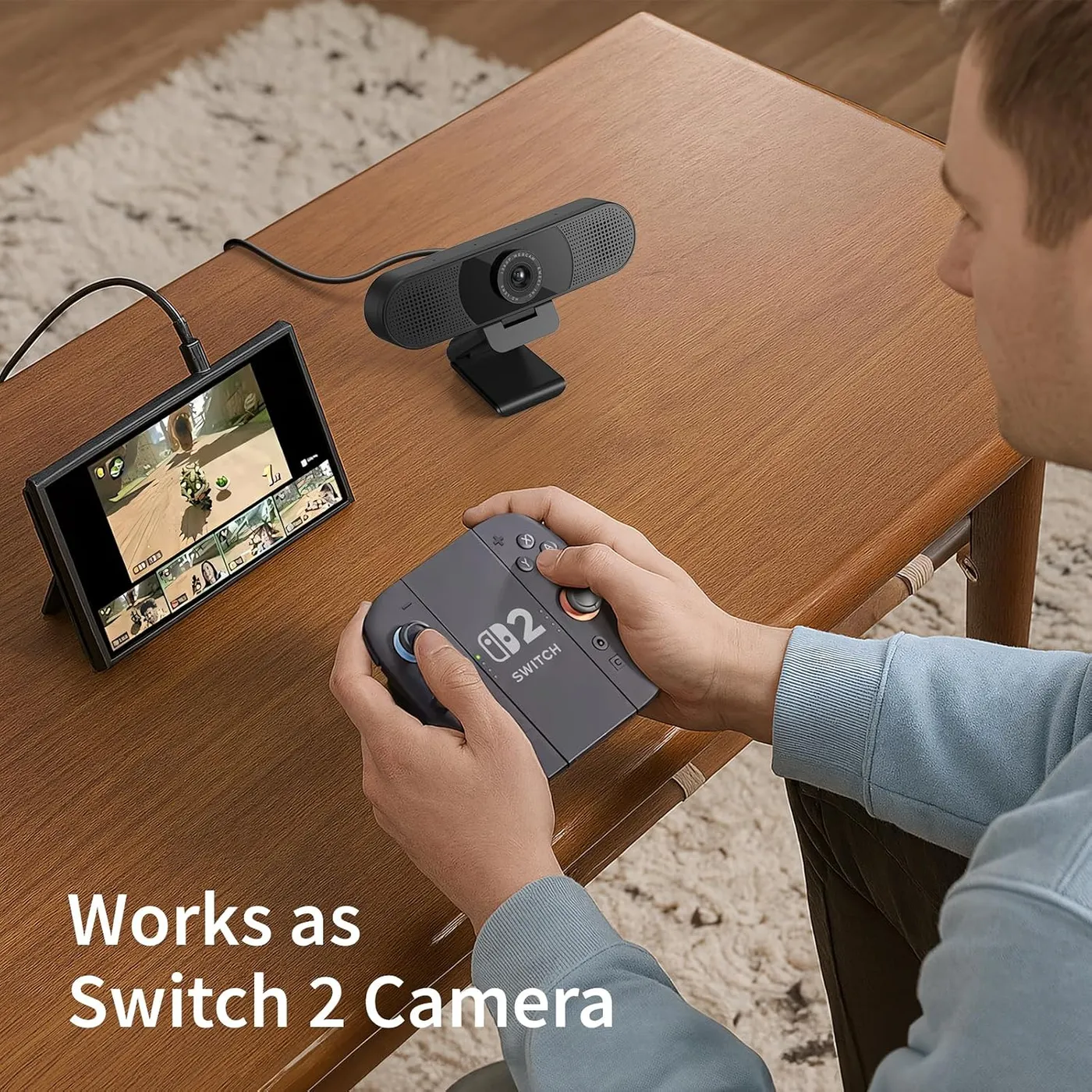 EMEET C960 1080P webcam on a wooden table beside a Switch 2 handheld, a player holding the controller, camera caption