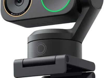 Insta360 Link 2 Pro webcam in black on its folding clip, with a green ring light and gimbal arm