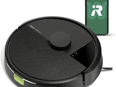 iRobot Roomba 105 Vac black robot vacuum from above with a fabric-textured lid, beside a phone showing the iRobot app