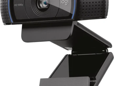 Logitech C920x HD Pro webcam in black with blue trim, three-quarter front view on its folding clip stand