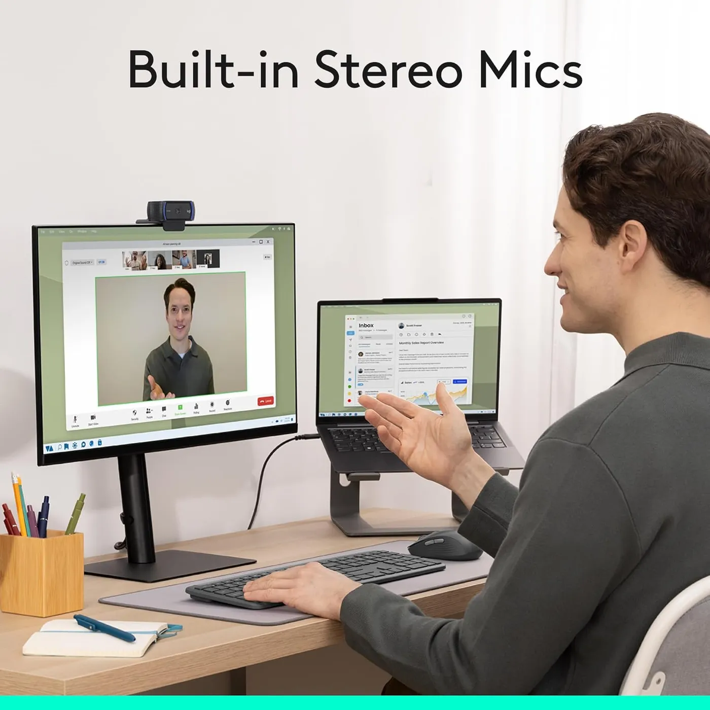 Logitech C920x HD Pro webcam mounted on a monitor in a home office, a man gesturing during a video call, stereo mics callout