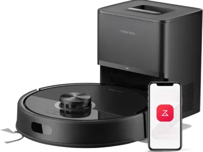 Roborock Q7 M5 Plus black robot vacuum next to its auto-empty dock and a phone showing the Roborock app icon